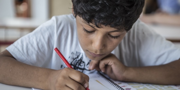 primo piano di un bambino che disegna su un foglio