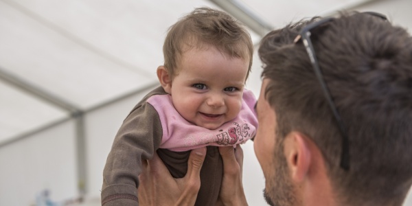 bambino che ride in braccio a uomo 