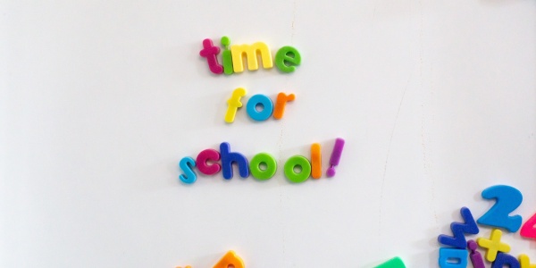 lavagna magnetica bianca con lettere colorate in basso a destra e in centro le lettere formano la scritta time for school