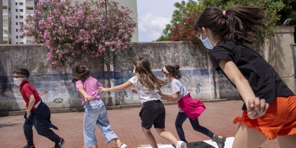 4 ragazze e un ragazzo che giocano a correre in un cortile