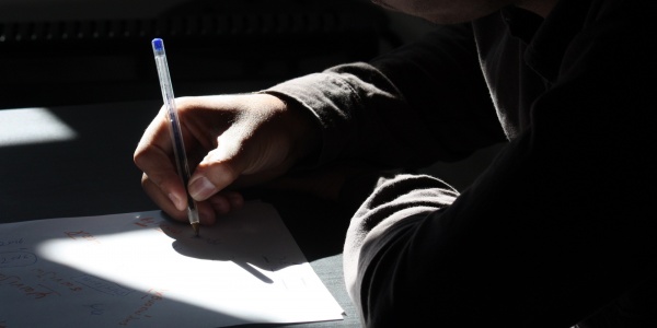 studente al banco di scuola scrive su un foglio