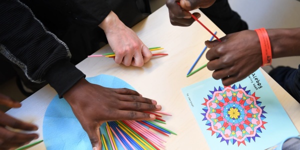 mani di ragazzini prese dall alto colorano un disegno appoggiato sul tavolo