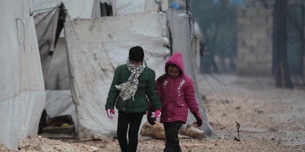 bambina e bambino che camminano in un campo per sfollati in nord est siria