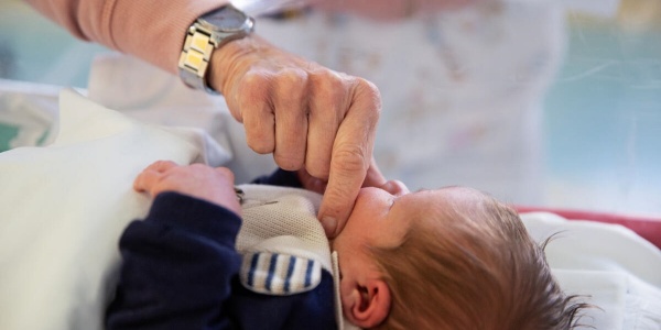 mano di un genitore a contatto skin to skin con neonato 