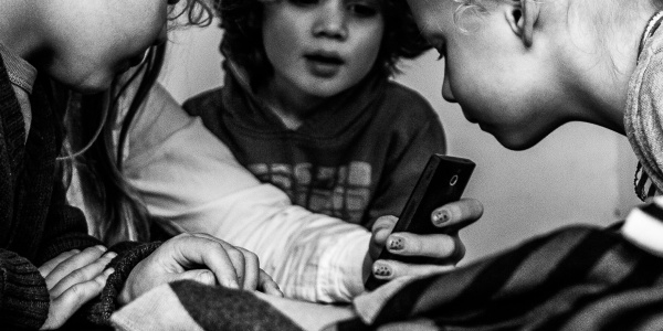 tre bambini guardano lo smartphone