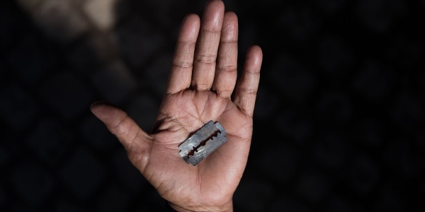 primo piano di un palmo della mano aperto che tiene una lametta