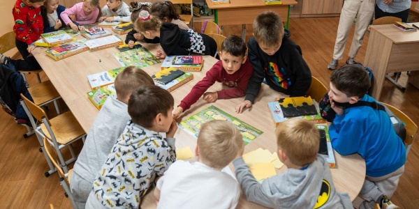 bambini e bambine ucraini con un gioco da tavolo per proteggersi dalle mine
