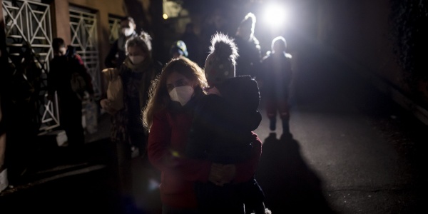 operatrice save the children con in braccio un bambino ucraino durante l'intervento di aiuto in Ucraina