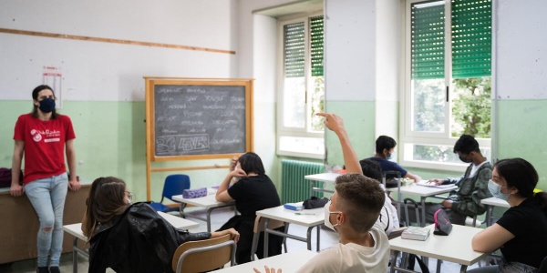 studenti e studentesse in aula scolastica con operatore Save the Children alla cattedra