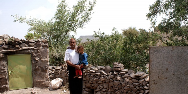 Uomo yemenita tiene in braccio un bambino 