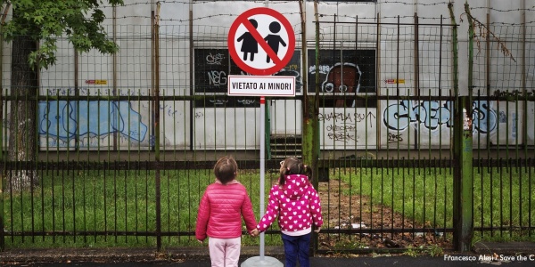 due bambine si tengono per mano davanti a un cartello di divieto con scritto "vietato ai minori"