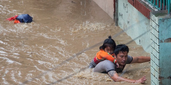 Un padre con la sua bambina che cerca di mettersi in salvo dall acqua alta