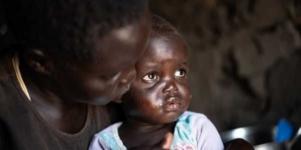 Una bambina di due anni del Sud Sudan con sua madre nel campo rifugiati in Uganda