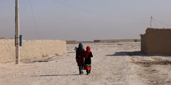 Due bambine afghane camminano verso il deserto. 